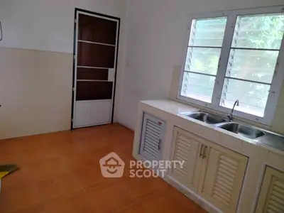 Spacious kitchen with dual sink and ample natural light, perfect for culinary enthusiasts.