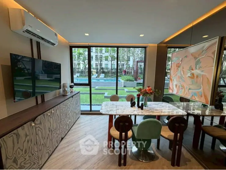 Luxurious living room with modern decor and large windows offering garden views.