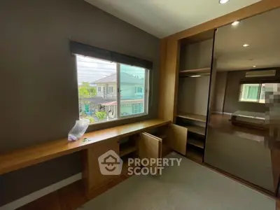 Spacious bedroom with built-in wardrobe and large window offering natural light.