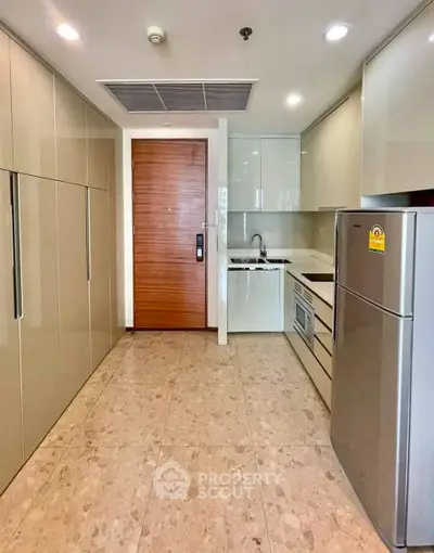 Modern kitchen with sleek cabinets and stainless steel appliances in a stylish apartment.