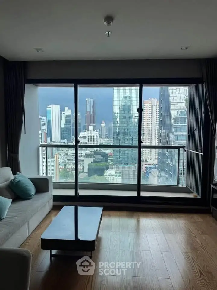 Stunning city view from modern living room with floor-to-ceiling windows and sleek furnishings.