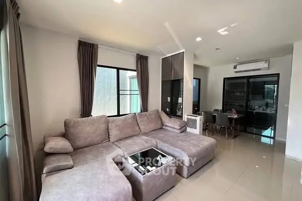 Spacious modern living room with large sectional sofa and dining area