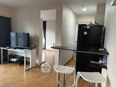 Modern living room with open layout and stylish furniture, featuring a sleek TV setup and bar counter.