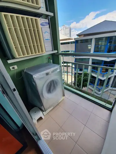 Charming balcony with washing machine and city view, perfect for urban living convenience.