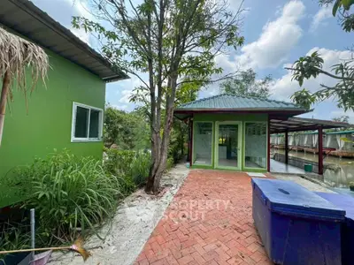 Charming green exterior house with lush garden and serene surroundings, perfect for nature lovers.