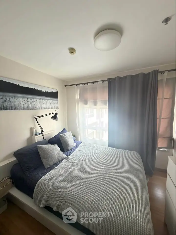 Cozy bedroom with modern decor and ample natural light, featuring a comfortable bed and stylish curtains.