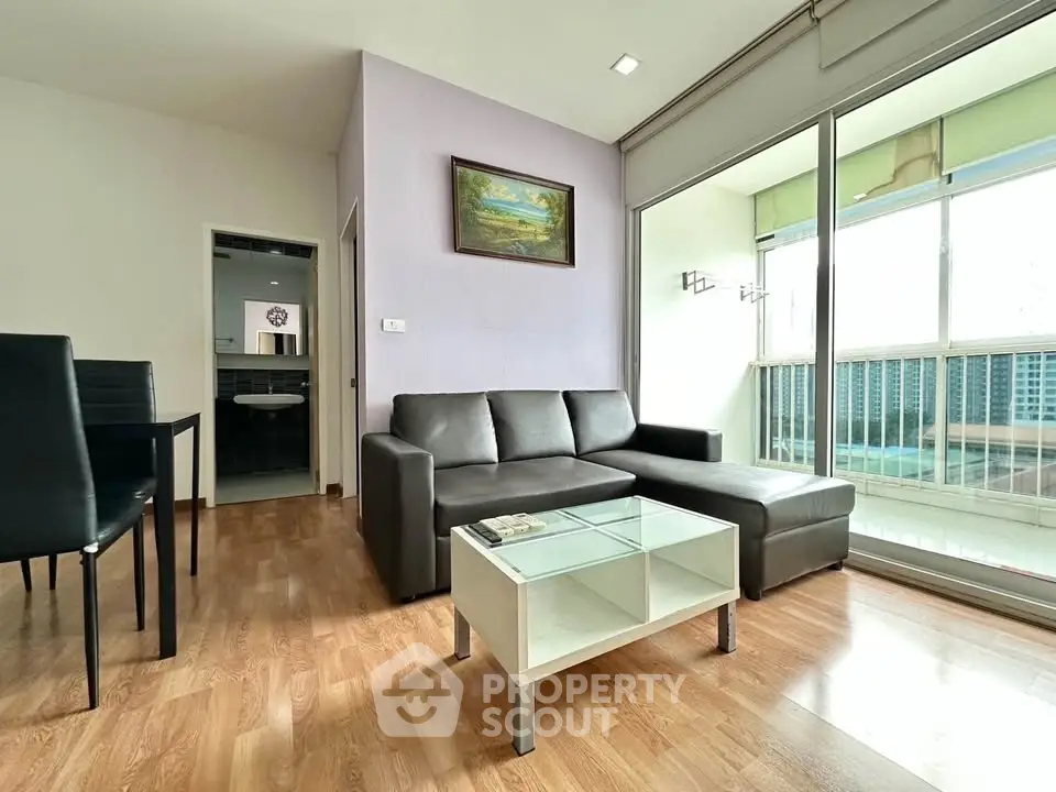 Modern living room with large windows and stylish furniture in a bright apartment.