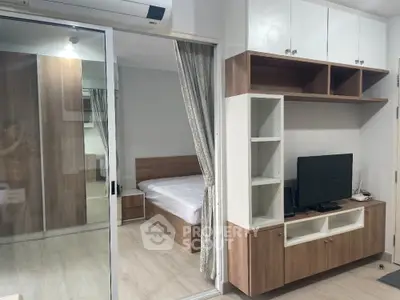 Modern apartment interior with bedroom and living area, featuring sleek wooden furniture and built-in storage.