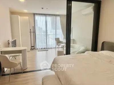 Spacious modern bedroom with large windows and elegant furnishings in a high-rise apartment.