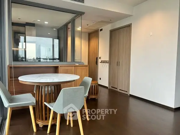 Modern dining area with stylish chairs and wooden flooring in a contemporary apartment.