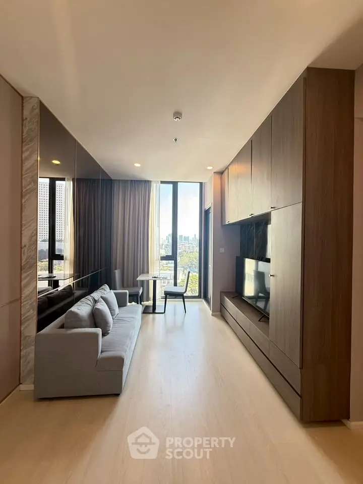 Modern living room with city view, featuring sleek furniture and floor-to-ceiling windows.