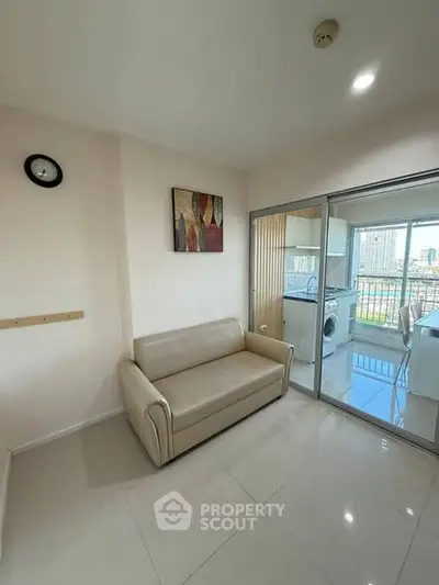 Modern living room with beige sofa and glass sliding doors to kitchen