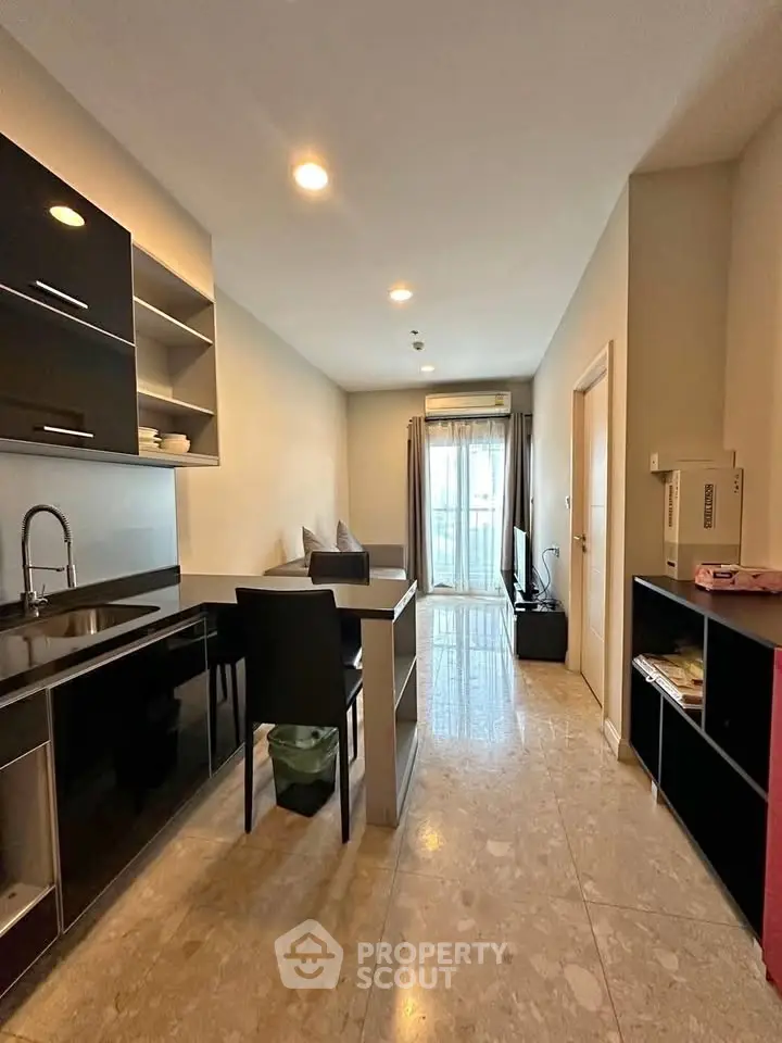Modern apartment interior with sleek kitchen and cozy living area, featuring natural light and contemporary design.