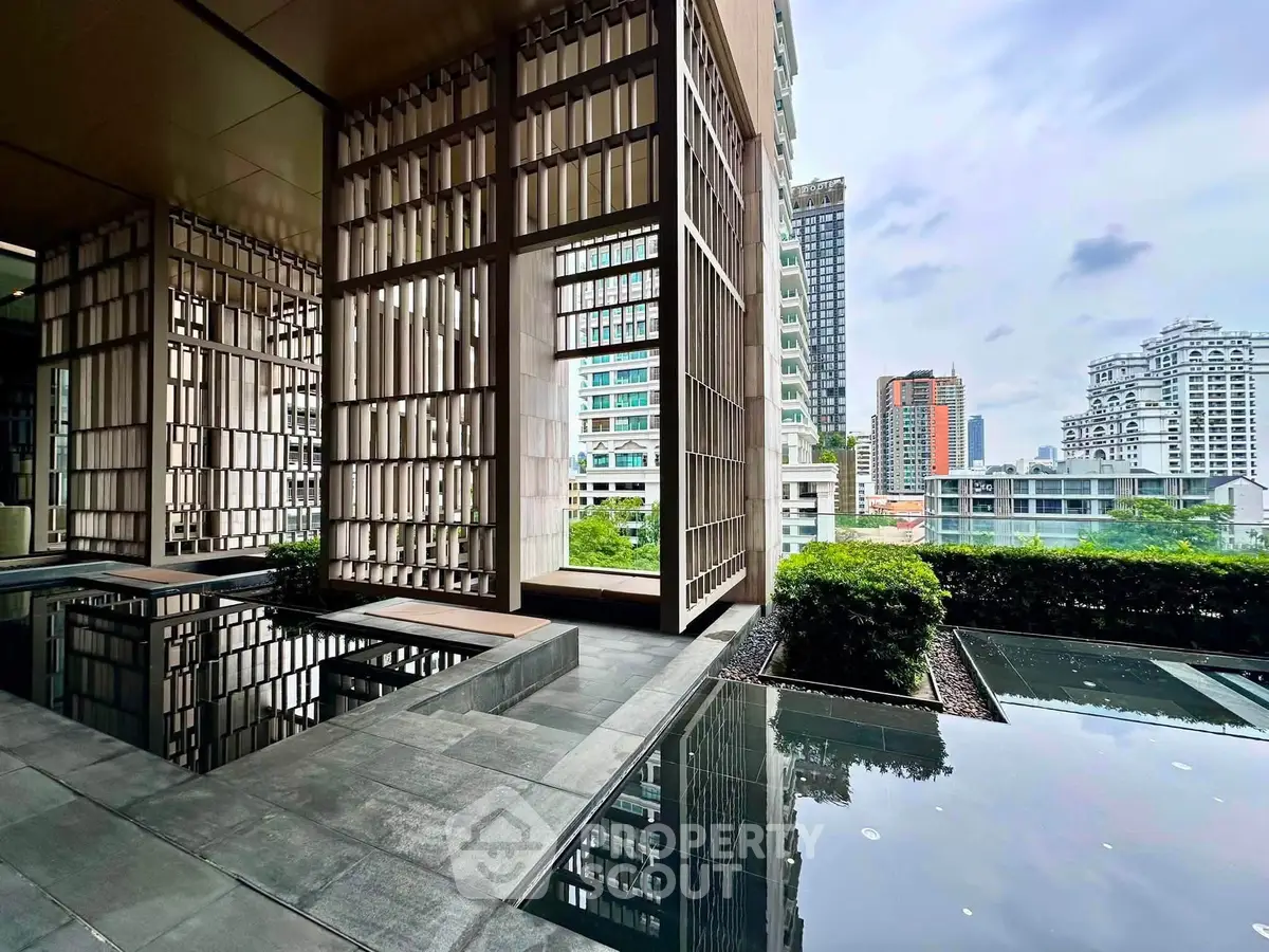 Stunning modern building exterior with water feature and city skyline view, perfect for urban living.