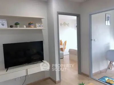 Modern living room with sleek TV setup and stylish decor in a cozy apartment.