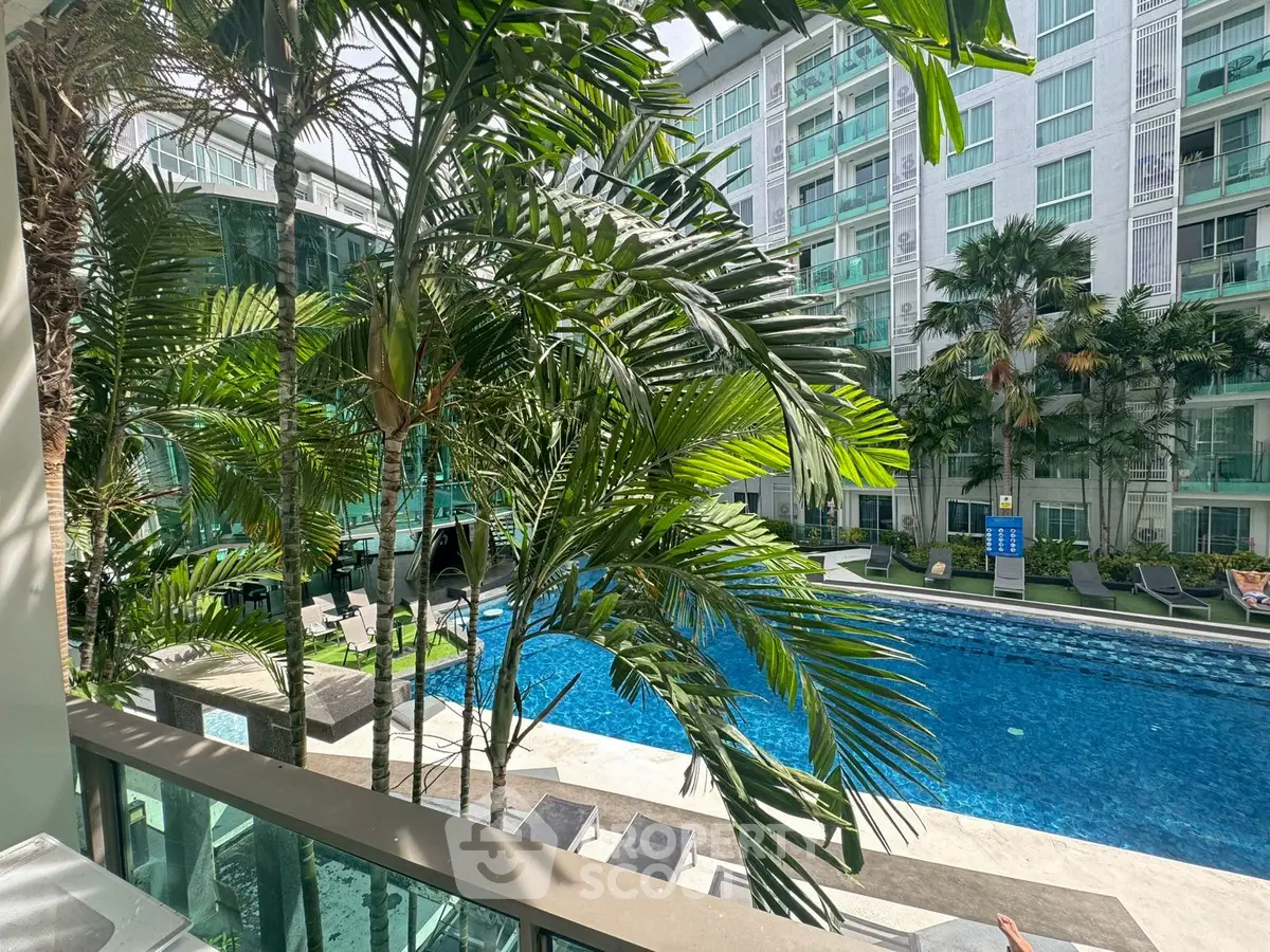 Luxurious poolside view with lush greenery and modern apartment complex.