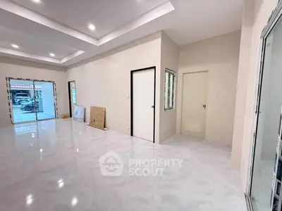 Spacious modern living room with sleek flooring and large windows for natural light.