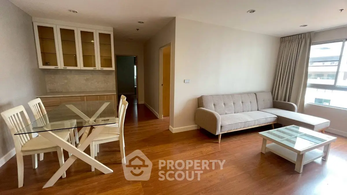 Modern living room with glass dining table and cozy sofa in bright apartment