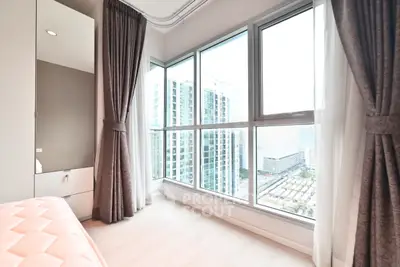 Bright bedroom with floor-to-ceiling windows offering stunning city views in modern high-rise apartment.