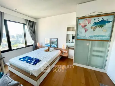 Modern bedroom with city view, wooden flooring, and stylish decor.