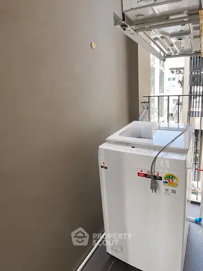 Modern apartment balcony with washing machine and city view