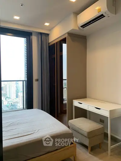 Modern bedroom with city view, featuring a cozy bed, desk, and air conditioning in a high-rise apartment.