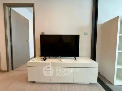 Modern living room with sleek TV stand and flat-screen TV, showcasing minimalist interior design.