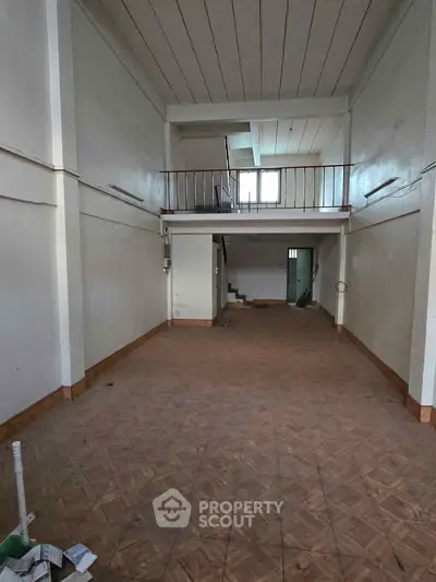 Spacious interior with high ceilings and mezzanine, ideal for creative renovation.