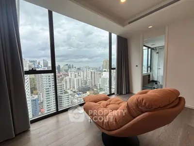 Luxurious high-rise apartment with stunning city view and cozy seating area.