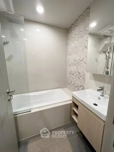 Modern bathroom with sleek design featuring a bathtub and stylish vanity.