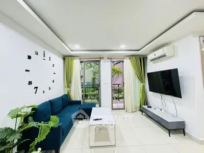 Modern living room with stylish decor and balcony view, featuring a sleek TV setup and comfortable seating.