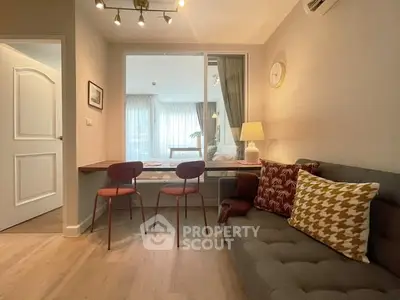 Modern living room with stylish decor and natural light, featuring a cozy sofa and elegant dining area.