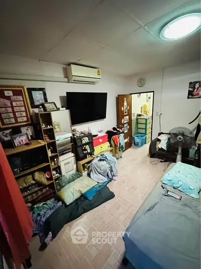 Cozy bedroom with TV, air conditioning, and organized storage solutions.