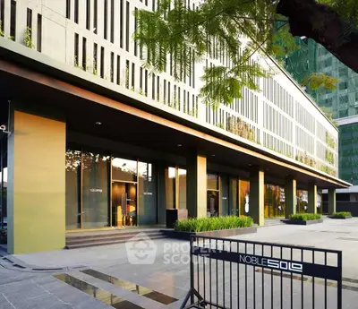 Modern building exterior with sleek design and lush greenery, showcasing urban sophistication.
