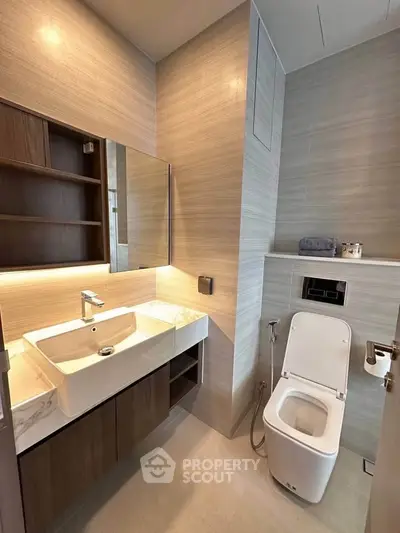 Modern bathroom with sleek fixtures and elegant design, featuring a stylish vanity and contemporary toilet.