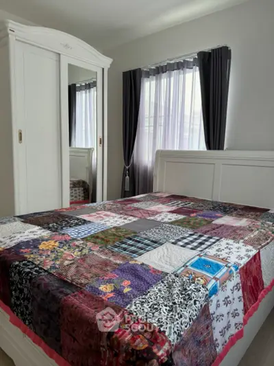 Charming bedroom with colorful quilt and elegant white furniture