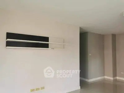 Spacious minimalist living room with modern shelving and neutral tones