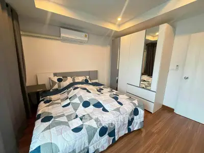 Modern bedroom with stylish decor and ample storage in a cozy apartment.