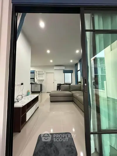 Modern living room with sleek design and open layout, featuring a comfortable sofa and stylish decor.