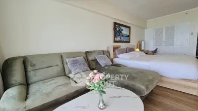Spacious living room with plush sofa and cozy bed, perfect for relaxation and comfort.