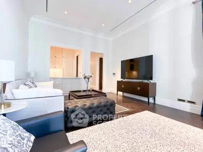 Luxurious living room with modern furniture and large TV, perfect for relaxation and entertainment.