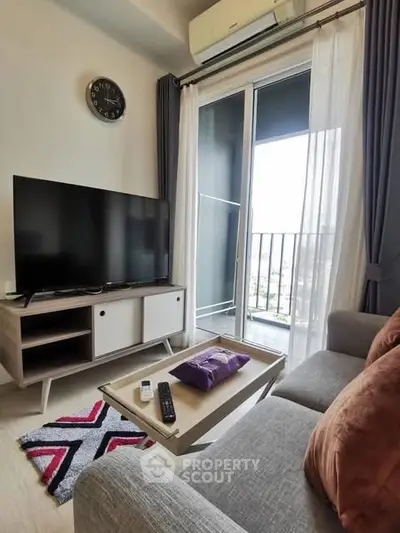 Modern living room with balcony view, featuring sleek furniture and stylish decor.