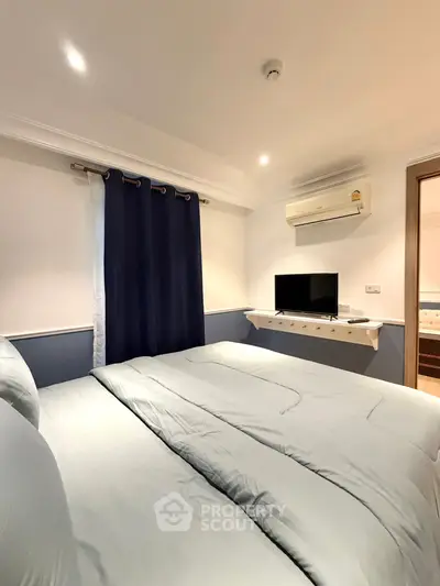 Cozy bedroom with modern decor and wall-mounted TV