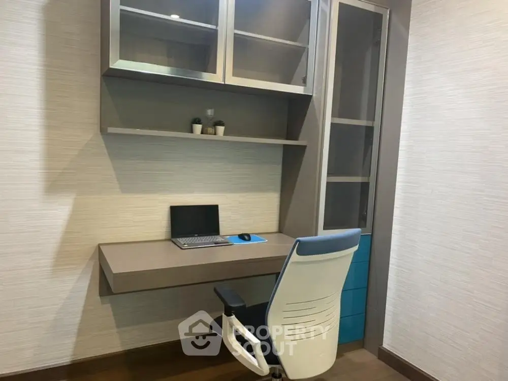 Modern study nook with sleek desk, chair, and shelving in a contemporary home office.