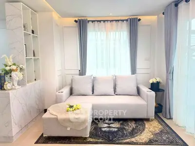 Elegant living room with modern sofa, stylish decor, and natural light from large windows.