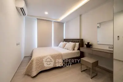 Modern bedroom with elegant decor and natural light, featuring a comfortable bed and stylish furnishings.