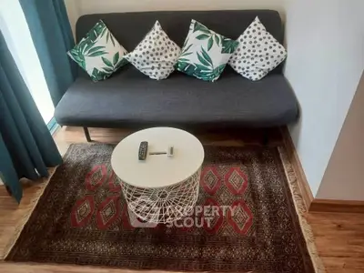 Cozy living room with stylish sofa, decorative pillows, and elegant rug, perfect for relaxation.