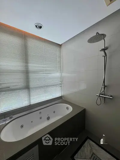 Luxurious bathroom with modern bathtub and rainfall shower, perfect for relaxation.