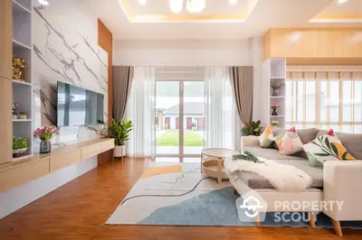 Spacious living room with modern decor, elegant furniture, and abundant natural light, leading to a serene outdoor view.