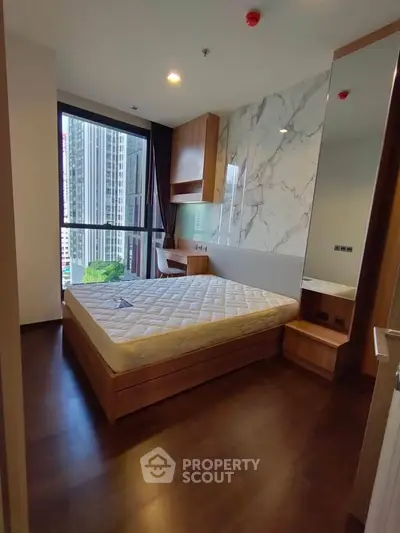 Modern bedroom with large window and city view in luxury apartment